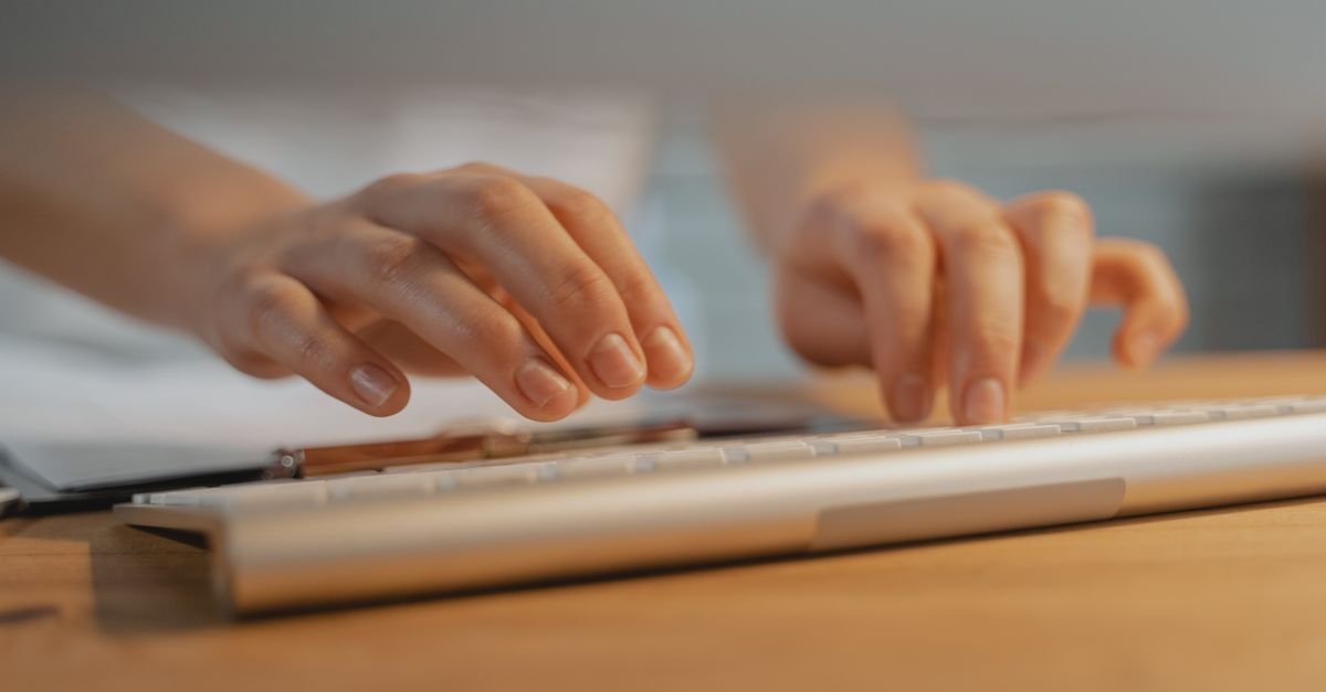 Two hands type on a white keyboard, the skill the smith ai jobs typing test measures.